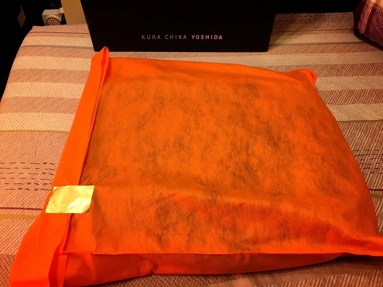 拿出提袋後,用一層橘色的不織布包覆著